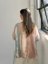 Sweater de punto con diseño abstracto en tonos camel, petróleo y crema, de corte holgado, escote en V y mangas largas con puños vueltos.