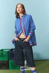 Camisa azul de algodón con detalles de ondas rojas en la solapa del cierre y en los puños, de manga larga y corte oversize.