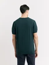 Remera de punto color beige, de manga corta y cuello redondo.