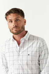 Camisa de manga larga blanca con patrón de cuadros finos en color azul oscuro. Presenta un corte slim y un pequeño logo bordado en el pecho.