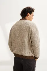 Campera estilo bomber color beige con textura, cierre delantero, cuello, puños y ruedo tejidos. Forrada, confeccionada en lana fina sin teñir.