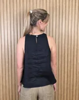 Musculosa de lino color negro, con escote halter y silueta suelta.