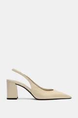 Zapato destalonado de piel en color beige, con punta fina, tacón ancho en bloque y tira trasera elástica.