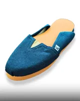 Alpargata de tela con diseño de rayas verticales en blanco y negro, con suela de goma color naranja y detalle elástico en el empeine.