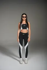 Calza deportiva larga negra con recortes laterales blancos.