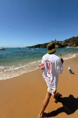 Remera blanca de manga corta con estampa de langosta roja en la espalda.