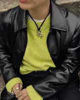 Collar con dije de bronce macizo con forma orgánica irregular, similar a un coral, suspendido de un cordón negro de seda natural anudado.