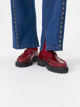 Zapato tipo guillermina de cuero color bordó, con diseño de mocasín, hebilla metálica y suela de goma con plataforma dentada.