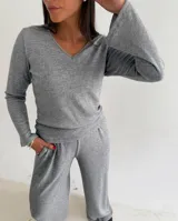 Remera de lanilla gris con textura acanalada, escote en V y mangas largas con terminación oxford.