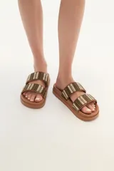 Sandalia tipo slide de color marrón, con doble tira ancha tejida en tonos tierra y negro, y suela anatómica de goma.