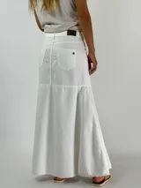 Pollera larga de jean blanca, corte recto con volado en el ruedo.