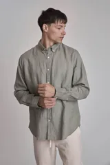 Camisa blanca de lino con cuello abotonado, manga larga con puños abotonados y corte clásico.