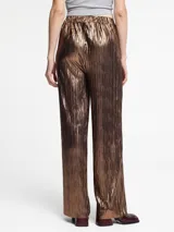 Pantalón de tiro medio con diseño plisado y acabado metalizado. Presenta un corte recto y holgado con cintura elástica para mayor comodidad.