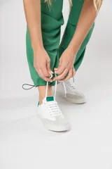 Zapatillas acordonadas de cuero color blanco con puntera de gamuza gris y detalles en verde.