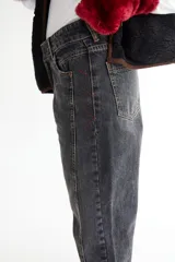 Jean negro de corte recto con recortes laterales, roturas en bolsillos, pespuntes a contratono y zigzag característico de la marca BG.