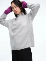 Sweater de cuello alto con textura suave y peluda, de corte holgado y mangas largas. Confeccionado en tejido de punto de cachemira.