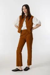 Pantalón de gamuza color marrón, de corte recto, con cierre lateral plateado, forro interno con stretch y tajos en el dobladillo.