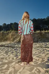 Falda midi de cuero marrón con detalle de crochet artesanal en el ruedo.