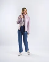 Campera entallada color lila, con capucha fija, cuello alto y cierre frontal completo. Presenta mangas largas y diseño de paneles curvos.