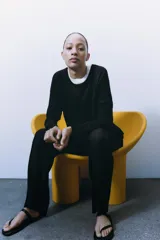 Jersey de punto liso, color azul brillante, con cuello redondo y manga larga. Presenta acabados en rib en puños, cuello y bajo, con aberturas laterales en el ruedo.