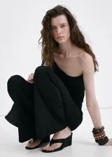 Pantalón de punto fino color negro, de diseño recto y tiro medio, con falda corta superpuesta integrada.