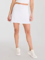 Falda blanca con calza interior de secado rápido, diseño acampanado y plisado en la parte trasera, bolsillo con cierre en la pretina y bolsillo interior en la calza.