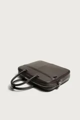 Maletín slim de textura grabada color marrón, con compartimento principal con cierre de cremallera, bolsillo interior para dispositivos electrónicos de hasta 13 pulgadas y bolsillo frontal con cierre. Incluye dos asas de mano y un asa de hombro ajustable y extraíble.
