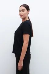 Blusa negra de broderie con mangas cortas y cuello redondo.