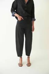 Jean slouchy de tiro medio, color negro, confeccionado en algodón. Presenta una silueta relajada con piernas abovedadas y botamanga ajustada.