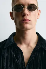 Sobrecamisa de corte relajado confeccionada en tejido de terciopelo fluido con acabado plisado. Presenta cuello solapa, cierre frontal de botones y manga larga con puños abotonados.