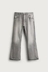 Jeans flare fit de denim negro, tiro medio, ajustados arriba y con botamanga acampanada. Cuentan con cinco bolsillos, lavado efecto gastado y bajo con acabado irregular. Cierre frontal con cremallera y botón.