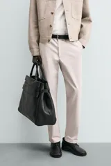 Pantalón chino de corte regular fit, confeccionado en tejido de algodón con elasticidad. Presenta bolsillos frontales, bolsillos traseros de vivo y cierre frontal con cremallera y botón.