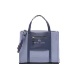 Cartera tipo tote pequeña de textura denim azul con detalles en cuerina azul oscuro, asas de mano y correa de hombro ajustable. Cuenta con un bolsillo frontal con cierre y el logo de la marca impreso.