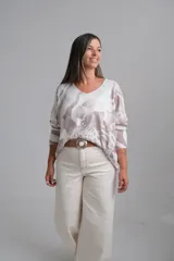 Sweter de punto con escote en V y mangas largas, presenta un diseño estampado abstracto en tonos tostado y blanco.