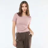 Camiseta de encaje color rosa con textura de puntos, corte ajustado, cuello redondo y mangas cortas con terminación ondulada.