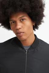 Campera bomber negra de poliéster con cierre frontal y cuello redondo.