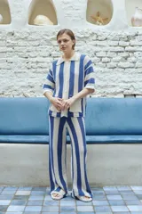Pantalón de punto calado a rayas verticales azules y blancas, con cintura elástica.