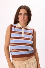 Top tejido sin mangas con diseño de rayas horizontales en tonos celeste, marrón y blanco. Presenta cuello tipo polo con cierre frontal de tres botones y terminaciones en tejido acanalado en el ruedo y las sisas.
