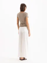 Pantalon wide leg blanco de lino, con tiro alto y bolsillos cargo laterales. Incluye cinturón con hebilla metálica.