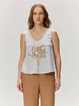 Musculosa de algodón gris melange, con escote en V y detalle de flor bordada en color dorado en el centro del frente.