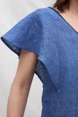 Vestido midi de lino en color azul, con escote en V tanto en el frente como en la espalda. Presenta mangas cortas con vuelo, silueta amplia y cintas verticales a contratono en el frente que estilizan la figura. Incluye bolsillos laterales.