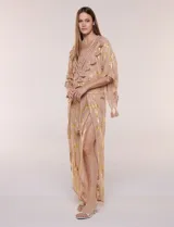 Pantalón palazzo confeccionado en gasa transparente color rosa con diseño estampado metalizado dorado. Presenta cintura elástica con cordón ajustable con borlas, piernas anchas y diseño cruzado al frente con aberturas laterales y detalles de puntillas.