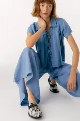 Zuecos de cuero color bordó con punta cuadrada, detalle de abertura en el empeine y aplique metálico dorado.