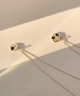 Collar de plata 950 con dije de forma orgánica irregular. El dije presenta un diseño inspirado en el cielo nocturno con dos piedras oscuras circulares, dos pequeñas piedras brillantes y detalles grabados en forma de estrellas.