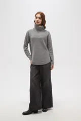 Polera de tejido de punto con cuello alto, diseño holgado y mangas largas. Presenta una textura de relieve tipo waffle en color natural.