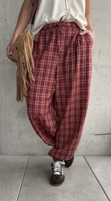 Pantalón estilo babucha color rojo con estampa a cuadros, tiro medio y cintura elástica con cordón ajustable.