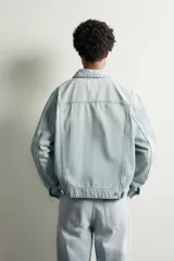 Cazadora de denim de algodón con corte regular fit, cuello solapa, cierre frontal con botones y bolsillos de vivo en la cadera. Presenta un acabado con efecto lavado.