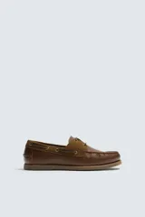 Mocasín náutico de cuero marrón, con cordones de cuero, ojales metálicos y detalles en gamuza a tono.