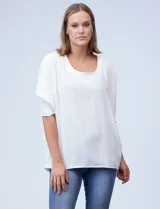 Blusa de crepe color blanco, con corte oversize, cuello redondo y mangas tipo dolman con puños elásticos en punto smock.