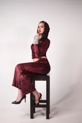 Conjunto de buzo y pantalón de terciopelo rojo con estampado animal print negro. El buzo es de corte ajustado, con capucha y cierre frontal. El pantalón es de corte acampanado y tiene un aplique de estrella de strass en la parte trasera.